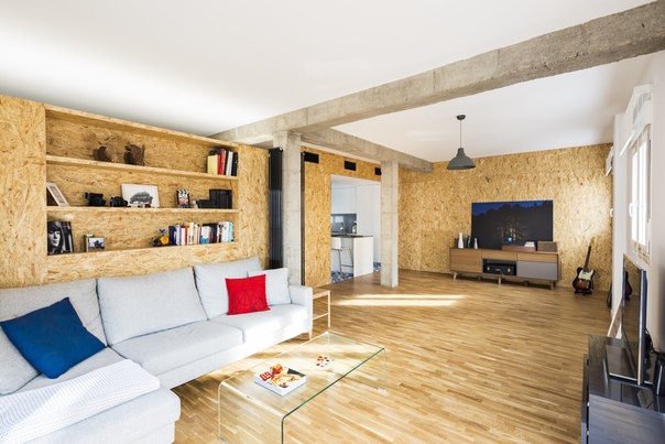 Квартира площадью 100 кв. метров в Испании в "современной" отделке. Тут мы видим мебель из OSB-плит и голые бетонные колонны с балками, обнажившиеся после сноса перегородок.
